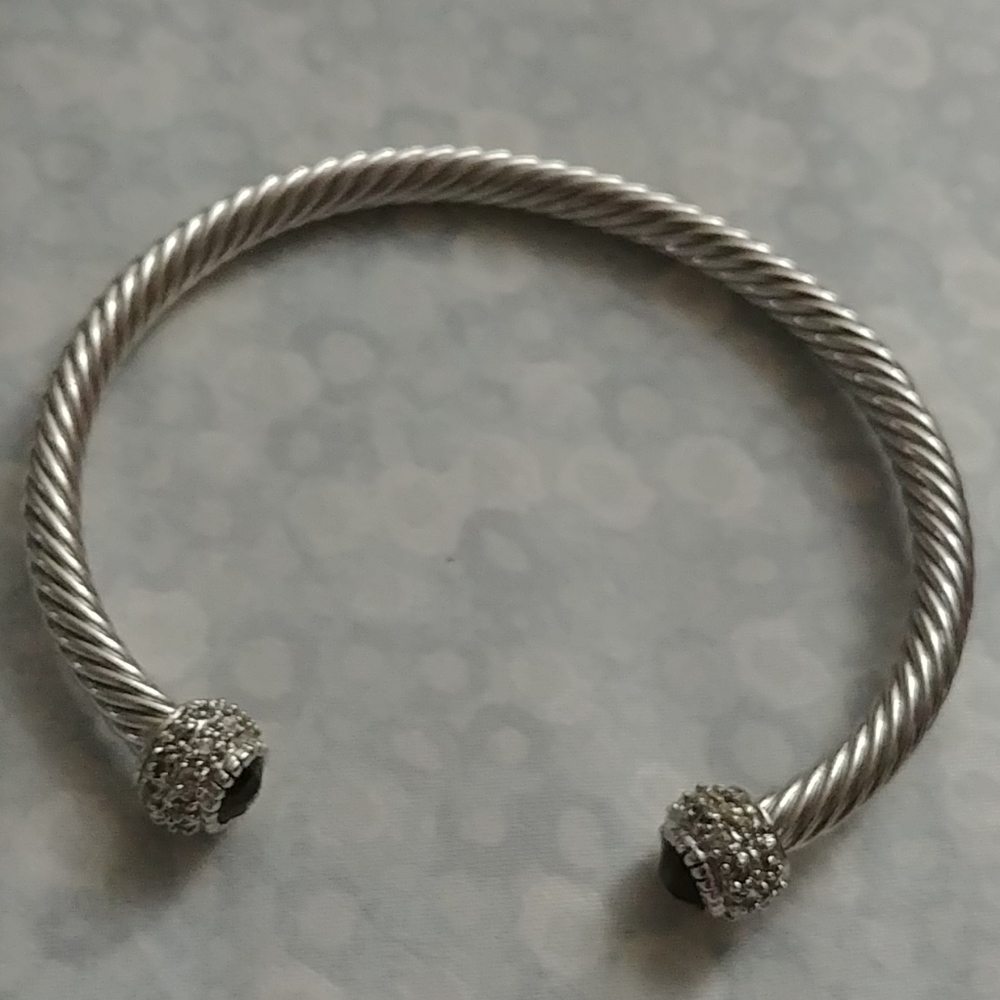 Twisted silver bracelet with zirconia around the e